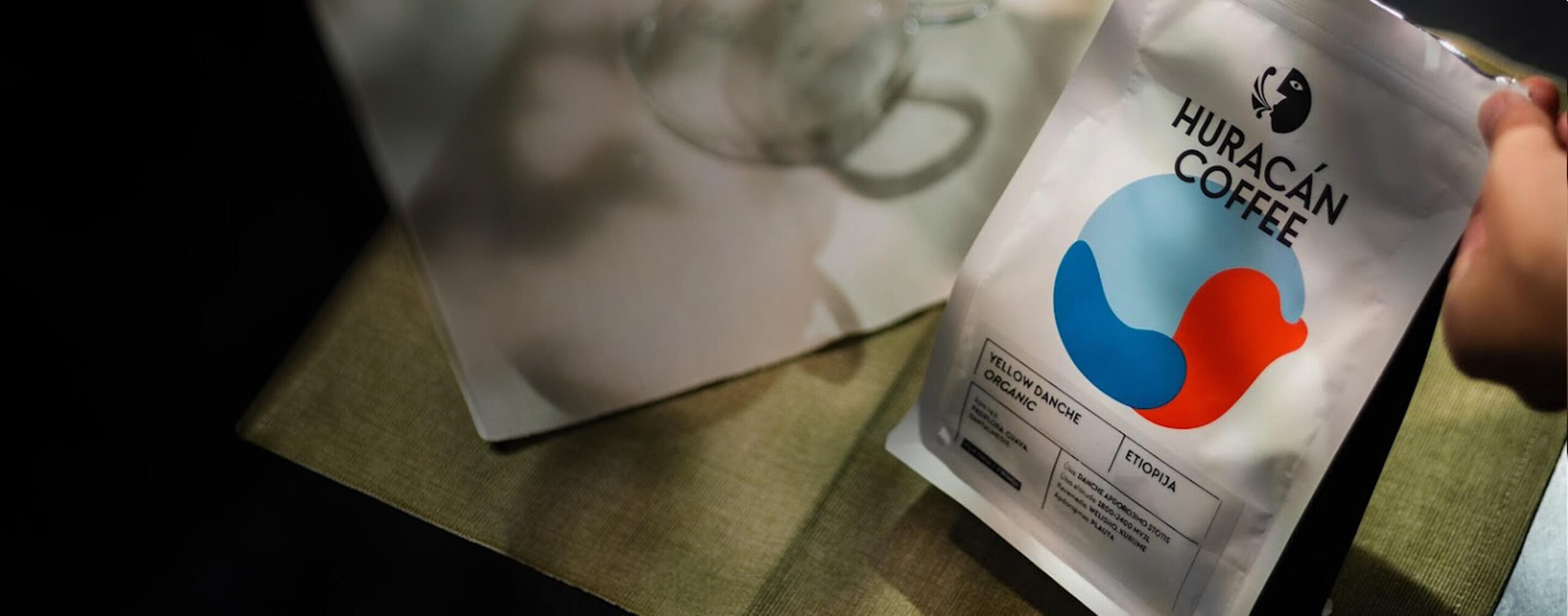 A bag of Huracán coffee held in a hand